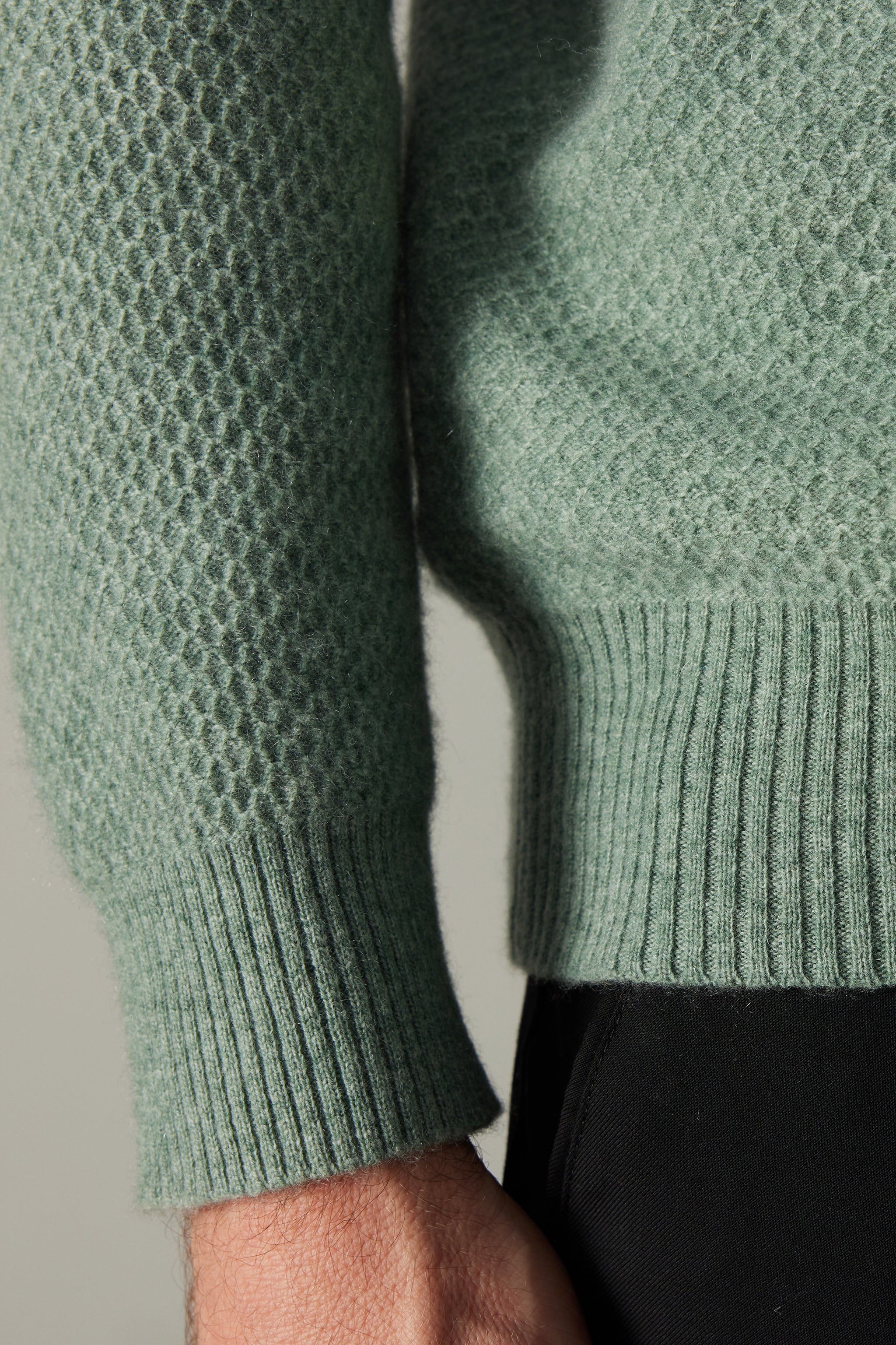 a close up of a person wearing a green sweater
